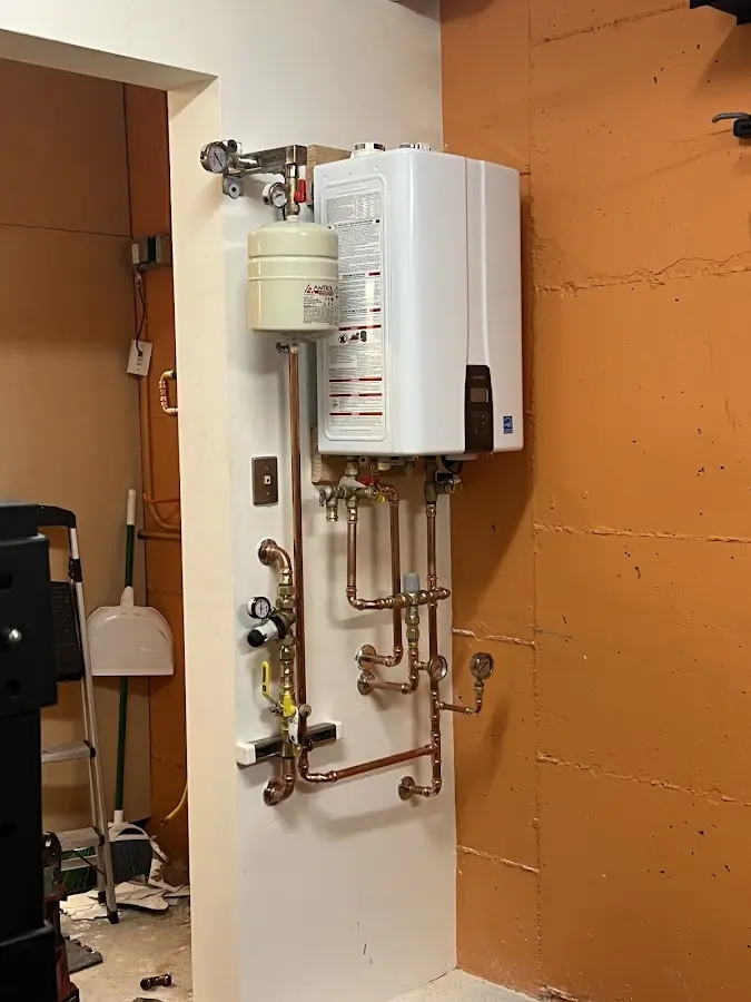 Plumbing technician inspecting water heater connections in Niagara